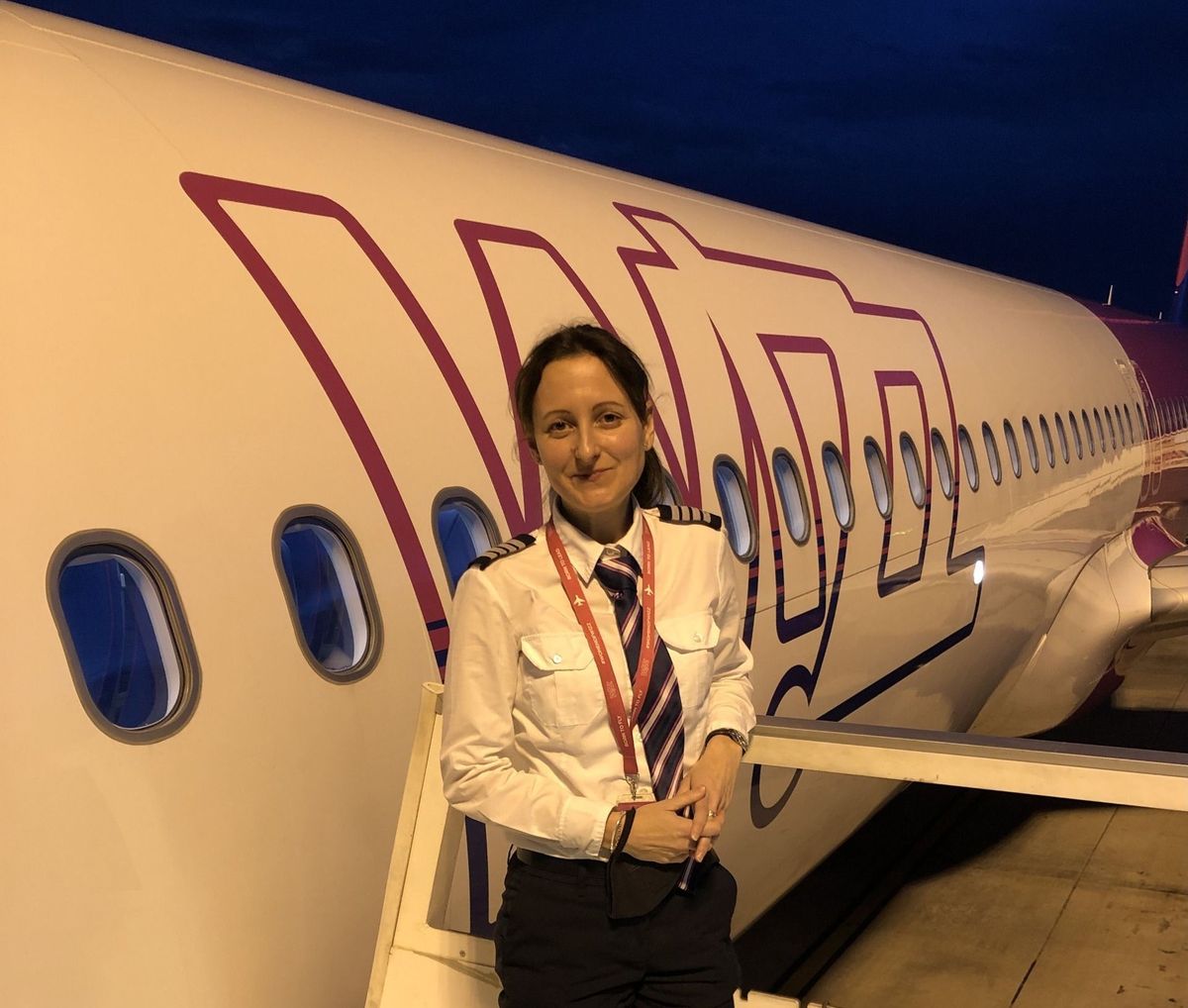 Malatinszky Anita női pilóta egy Wizz Air repülőgép mellett.