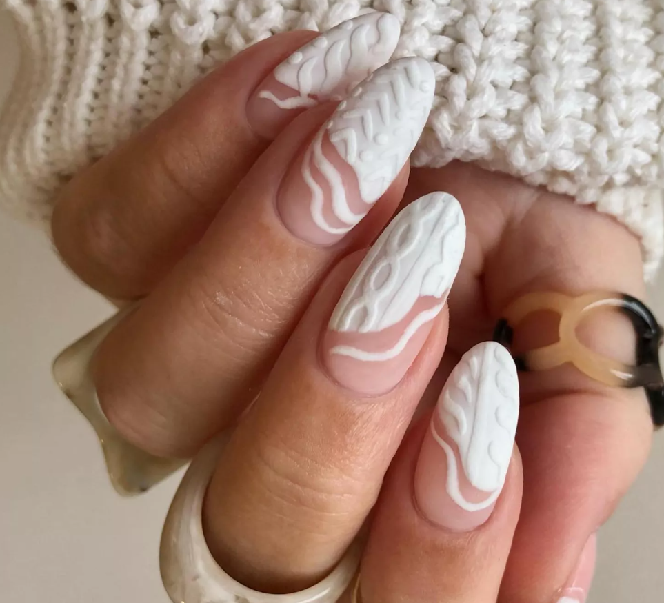 Kötött pulcsis körömminta fehér francia manikűrrel.
