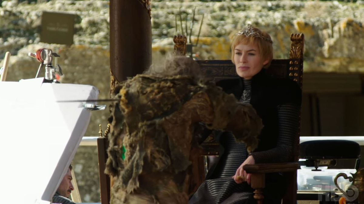 Cersei Lannister a Trónok harca sorozatban egy székben ül egy mással szemben a forgatáson.