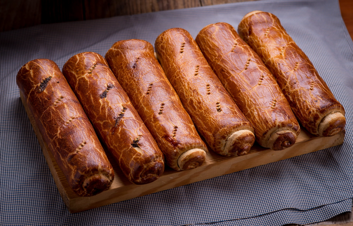 A kolbászos bejglik szépen sorban egymás mellé téve pihennek az asztalon.