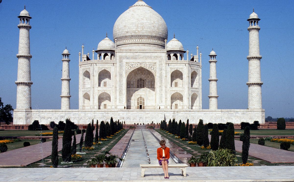 AGRA, INDIA - FEBRUARY 11: Diana, Princess of Wales, wearing a red and purple suit designed by Catherine Walker, poses alone outside the Taj Mahal on February 11, 1992 in Agra, India. 12 years earlier her husband, Prince Charles, Prince of Wales, posed in the same spot. (Photo by Anwar Hussein/Getty Images)