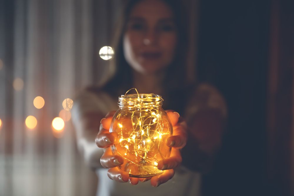 Nő égősorral a kezében a sorsfeladatán gondolkodik