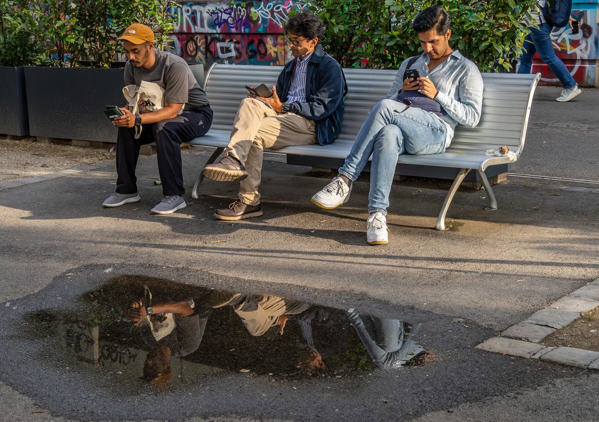 3 férfi ül a paodn és kijelzőt néz.