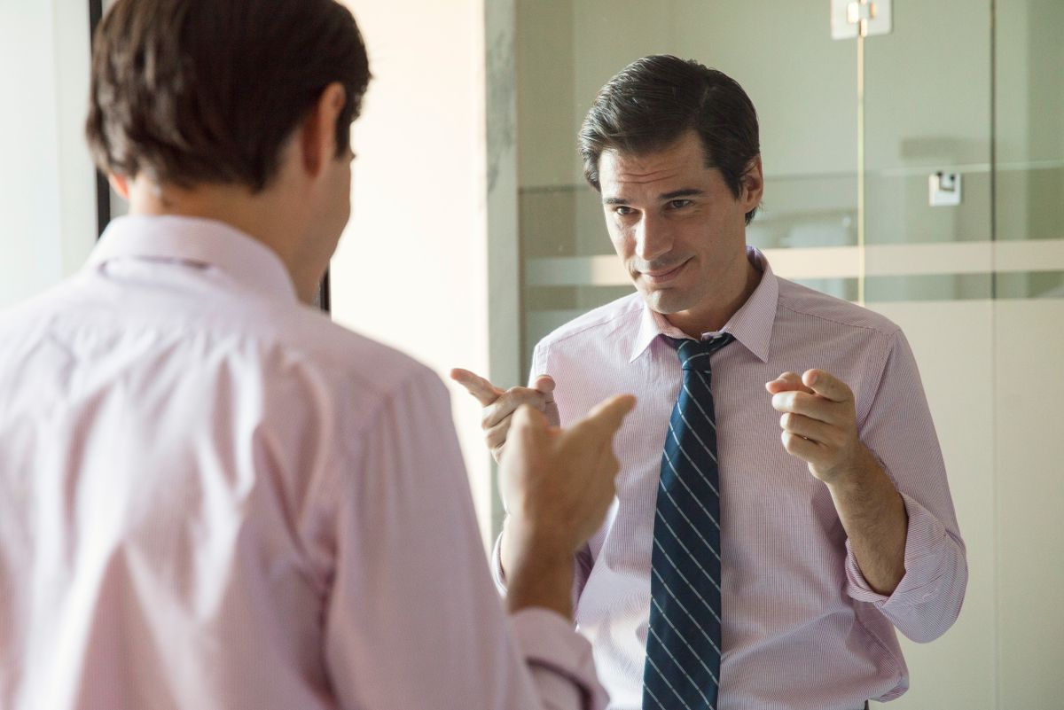 Egy nárcisztikus férfi a tükör előtt mosolyog. 