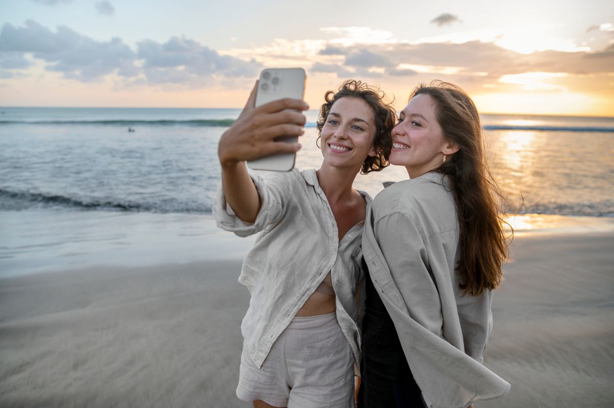 Két nő barátkozás közben a tengerparton szefizik egymással.