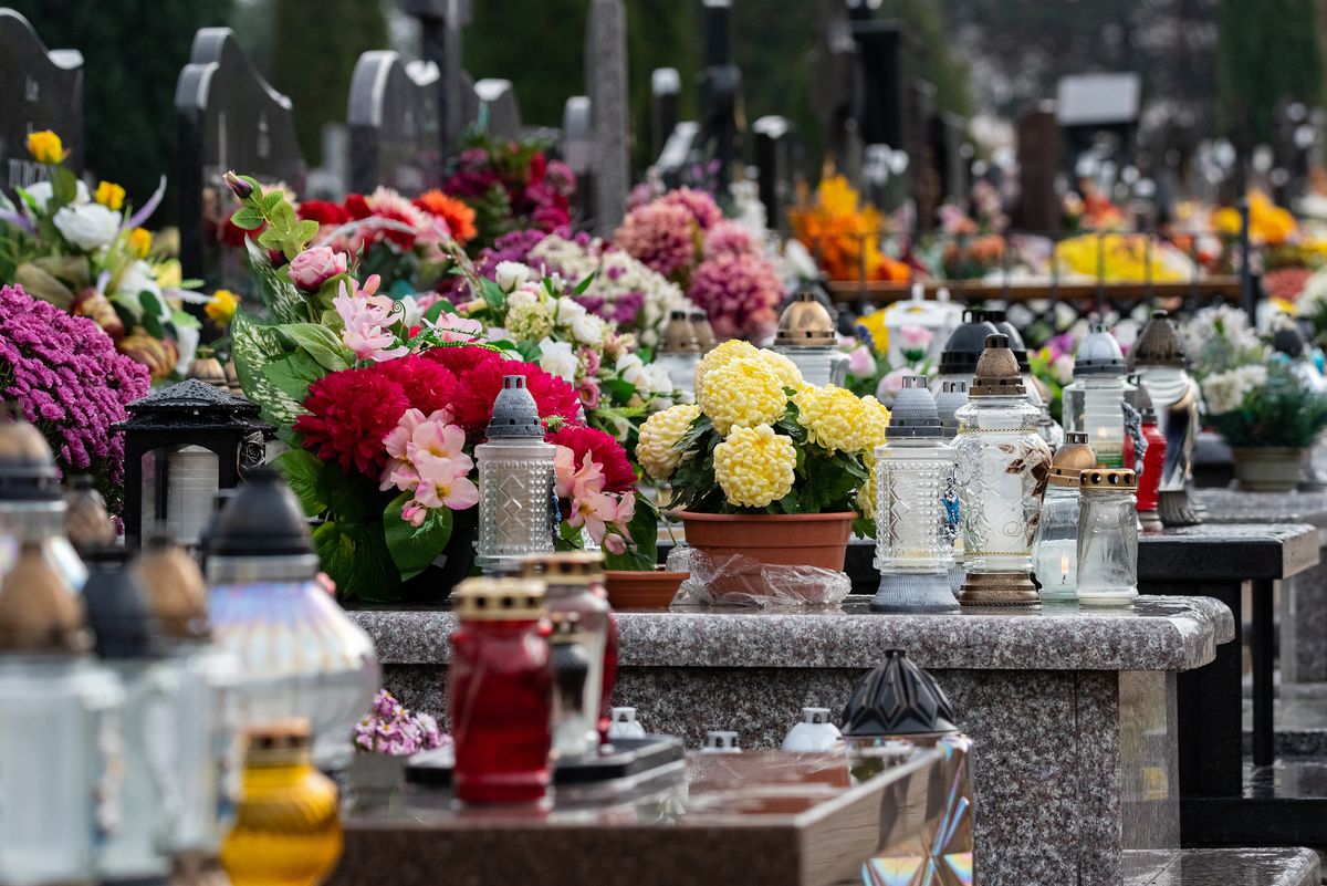 All Saints' Day and burning candles next to flowers on the graves. Candles on graves symbolize the memory of the dead on November 1. Catholic cemetery during All Saints' Day.