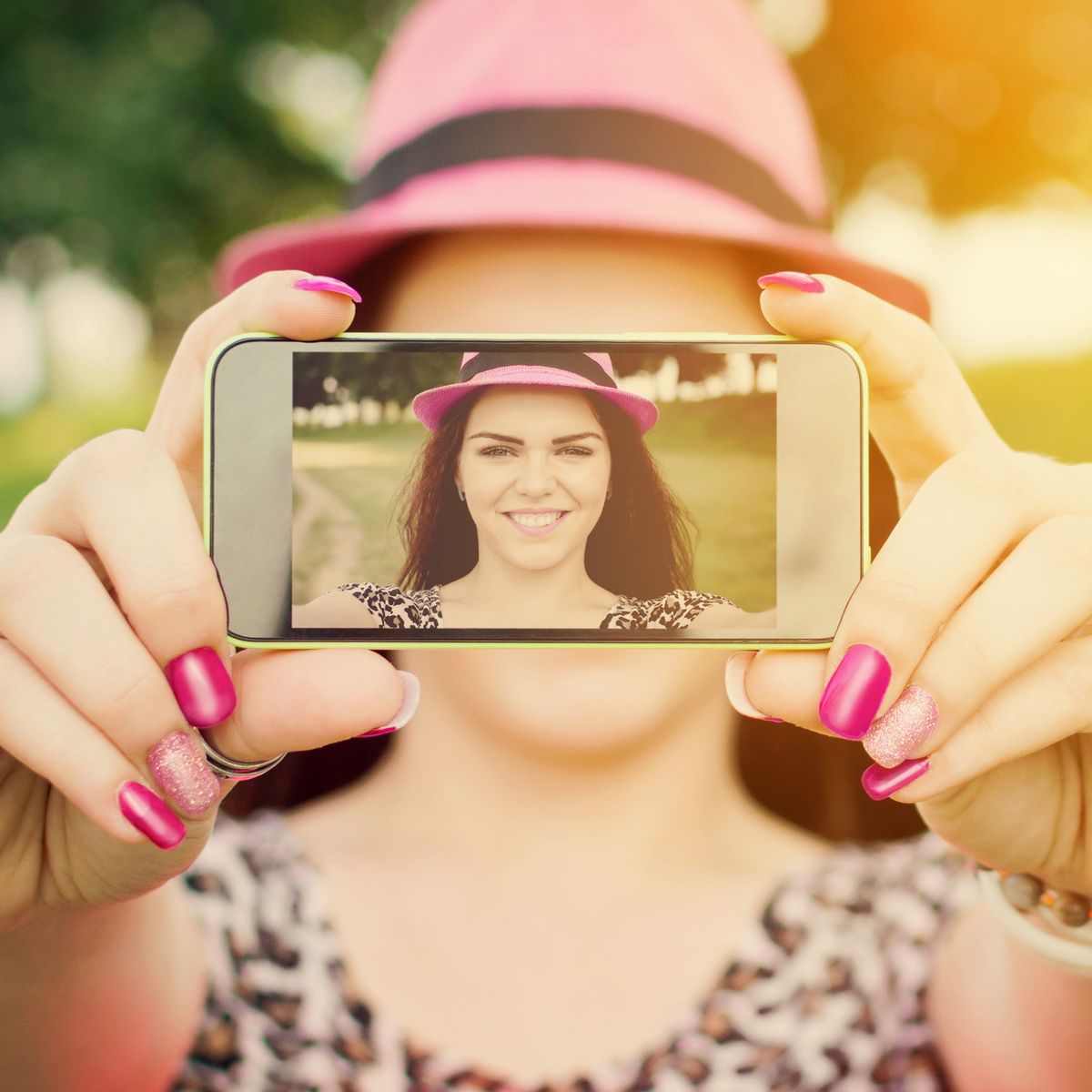 kamerát a kezében tartó mosolygó nő