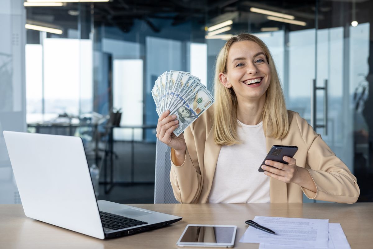 A legjobban fizető munkákból választó nő, pénzt tartva a kezében.