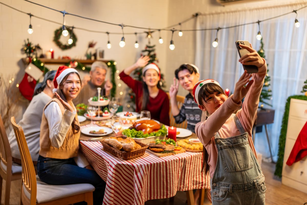 Család a karácsonyi asztalnál a túlevés előtt