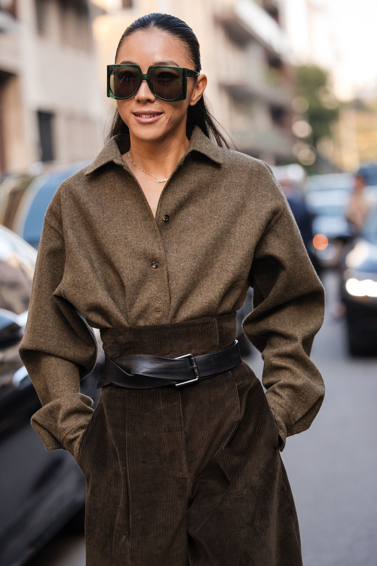 MILAN, ITALY - SEPTEMBER 25: Yuwei Zhangzou wears a monochromatic brown outfit, including a loose-fitting wool shirt and high-waisted wide-leg corduroy trousers, a wide black leather belt, chunky black boots, and sleek rectangular green sunglasses, outside Max Mara, during the Milan Fashion Week Womenswear Spring/Summer 2026 on September 25, 2025 in Milan, Italy. (Photo by Claudio Lavenia/Getty Images)
