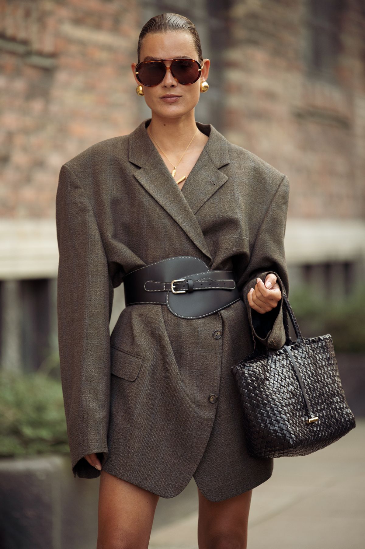 COPENHAGEN, DENMARK - AUGUST 08: Vera van Erp wears oversized brown blazer with black wide leather belt, sunglasses, back bag outside the Rotate show during day four of the Copenhagen Fashion Week (CPHFW) SS25 on August 08, 2024 in Copenhagen, Denmark. (Photo by Raimonda Kulikauskiene/Getty Images)