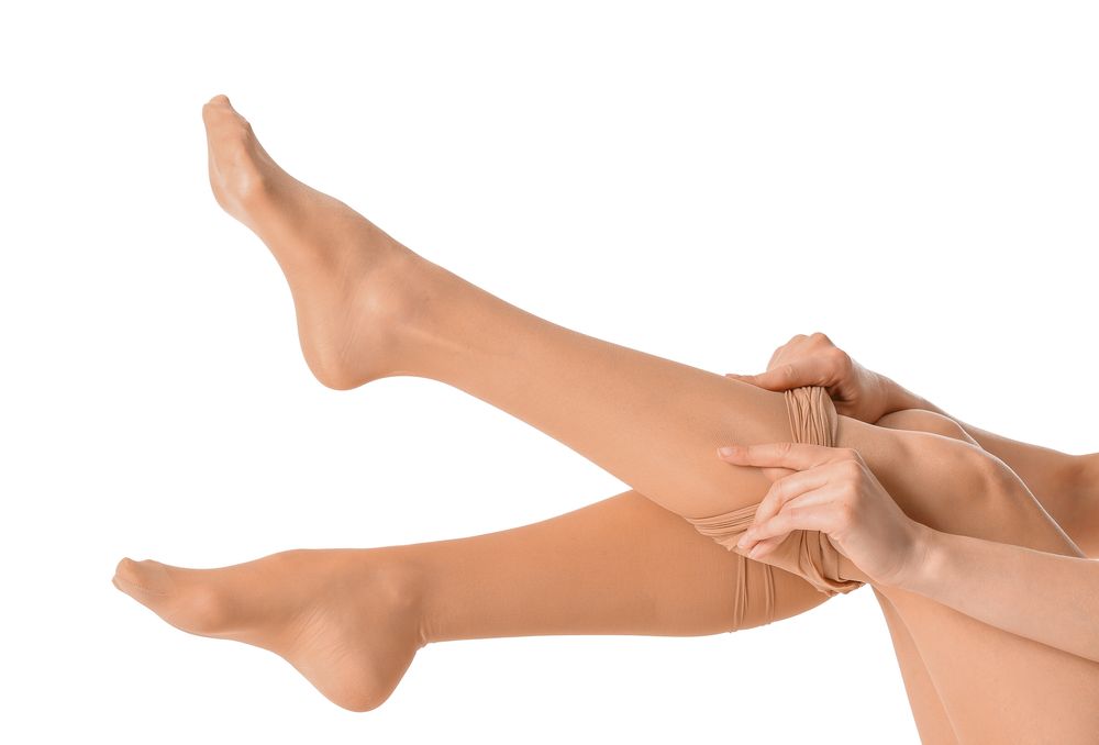 Nő testszínű nylonharisnyát húz fel