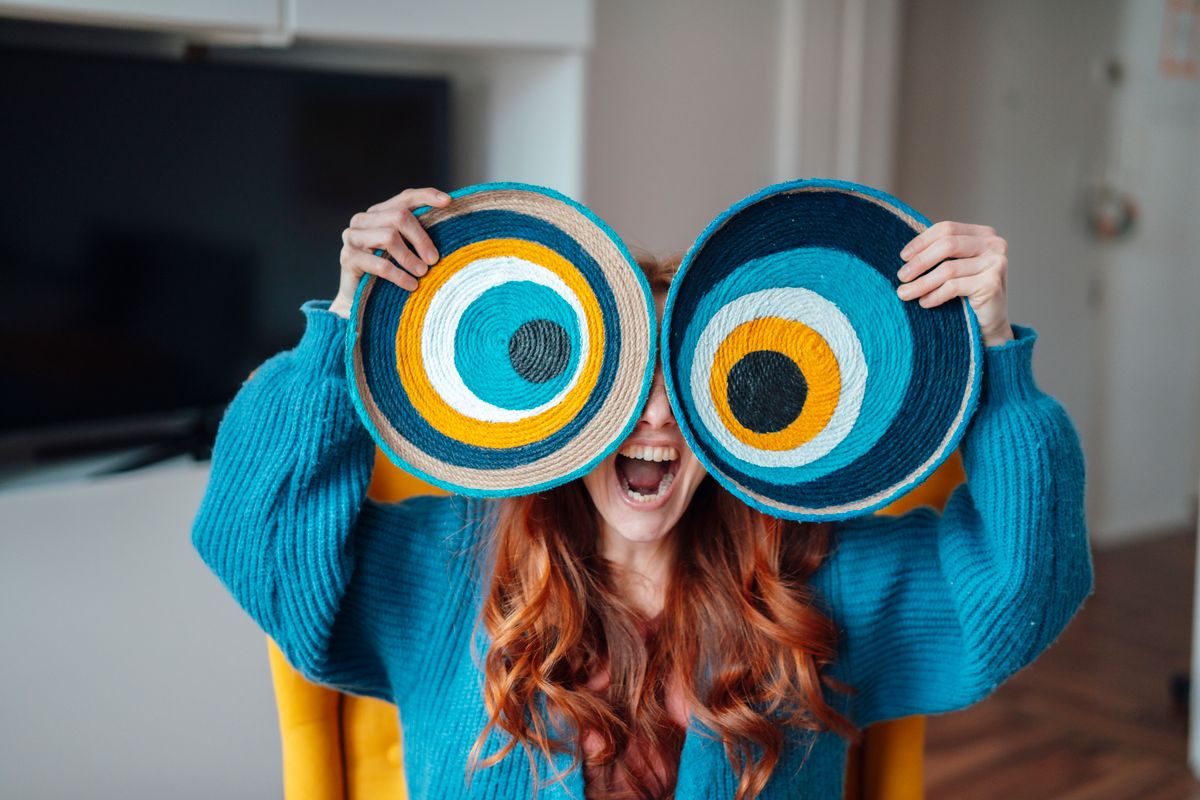 Kvíz, egy nagy szemeket tart nő kék pulcsiban.