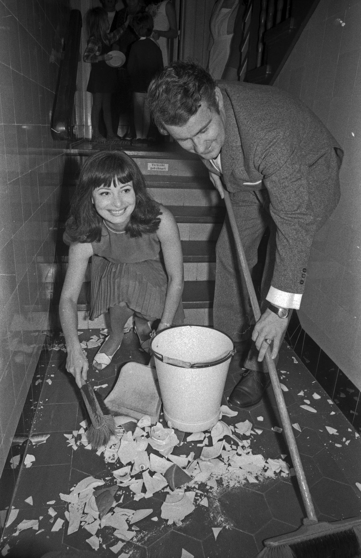 Esküvői szokások Németországban: törött porcelánt takarít egy német pár. 