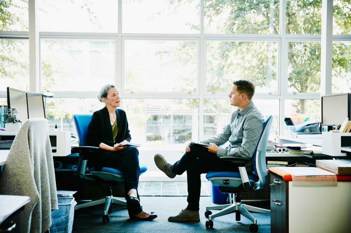 Intelligens emberek: egy nő és egy férfi beszélget a munkahelyén. 