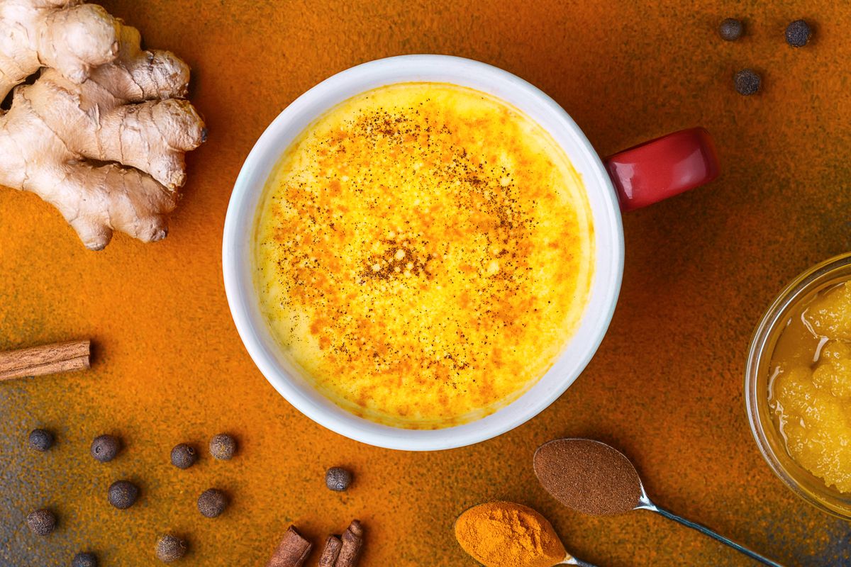 Aranytej: kötben a szükséges fűszerek, középen az aranytej felülnézetből egy bögrében.