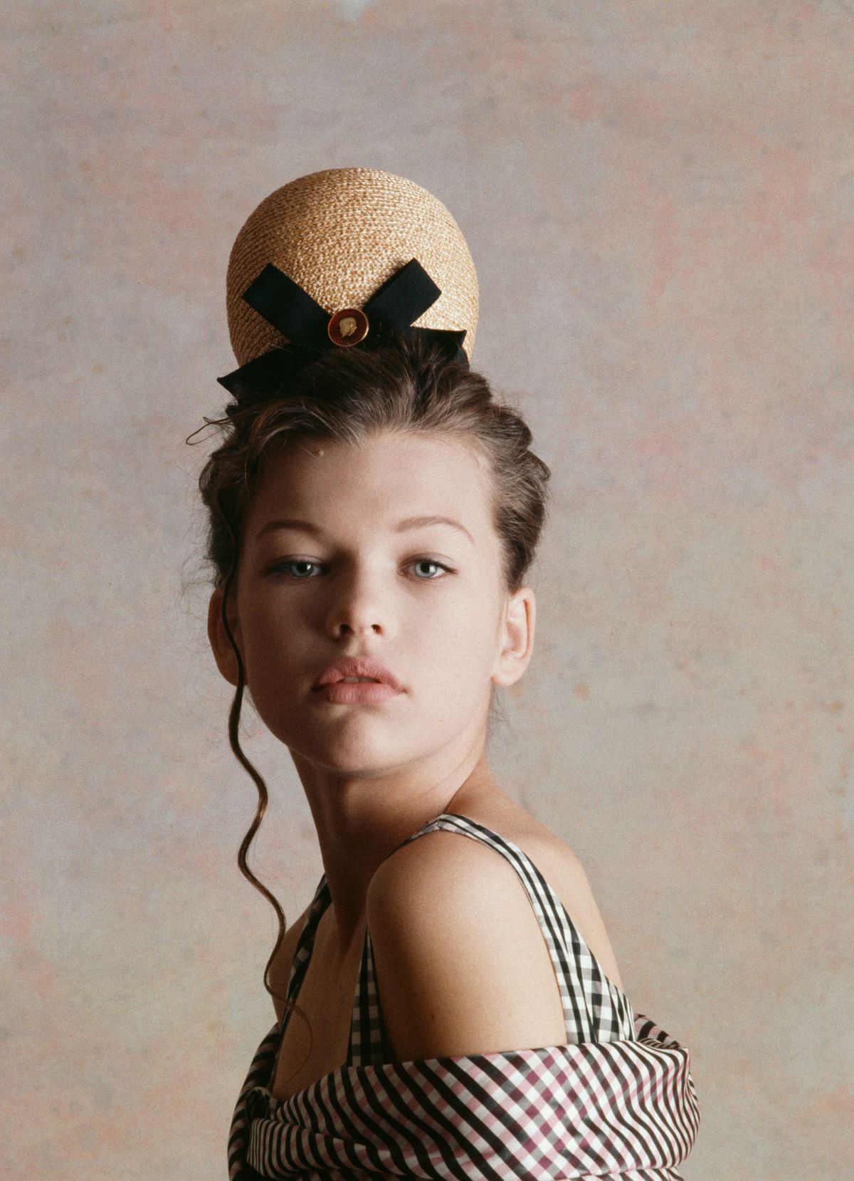 Young actress and fashion model Milla Jovovich at the age of twelve wearing a plaid shirt and hat by French designer Christian Lacroix. Jovovich began her modeling career at the age of eleven, 1987. (Photo by julio donoso/Sygma via Getty Images)