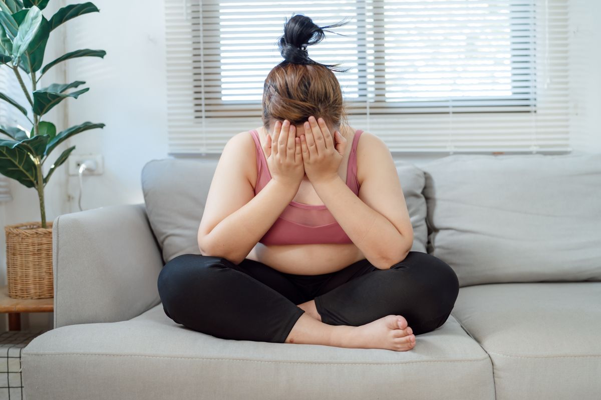 Életmódváltás: dundi nő a kanapén sír, mert nem fogy olyan gyorsan, mint remélte.
