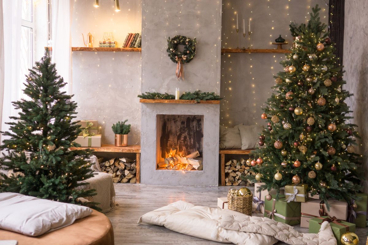 The interior of the Scandinavian-style living room, decorated for the Christmas holidays. Christmas tree next to the fireplace