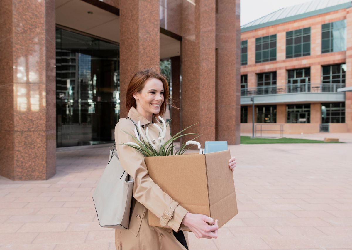 Egy fiatal nő bolgodan hagyja el az irodát munkahelyváltás után, mikor kilépett a cégtől. 
