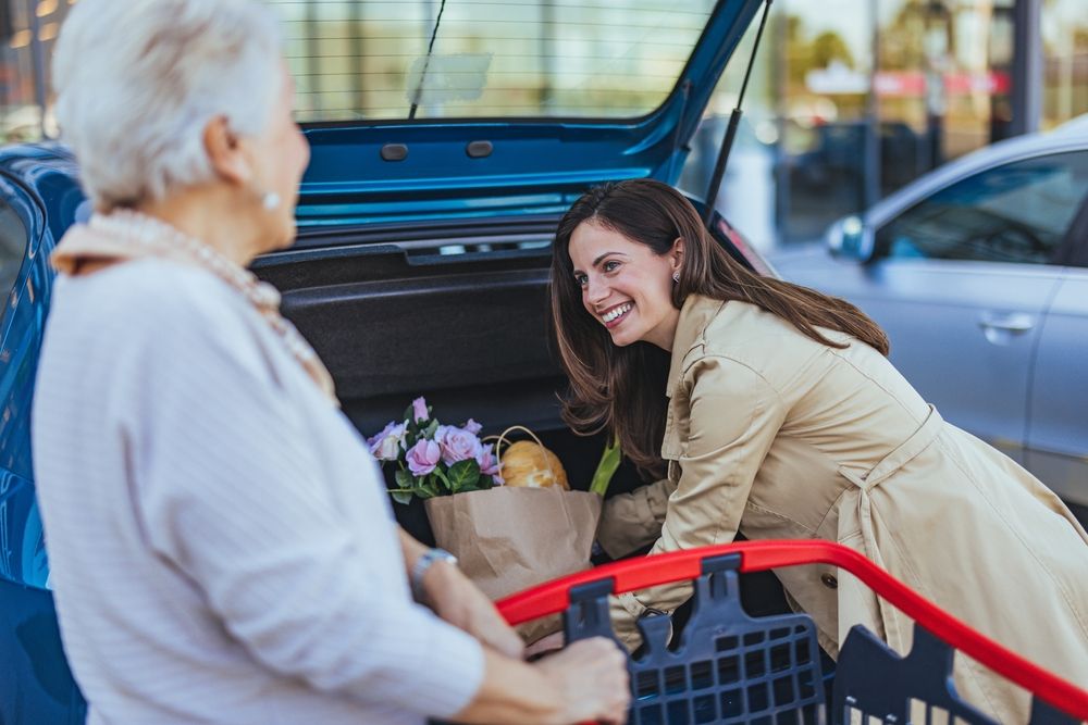 A szülőség sikere, ha gyermeked tisztel másokat. Nő segít idősebb hölgynek a bevásárlásban. 