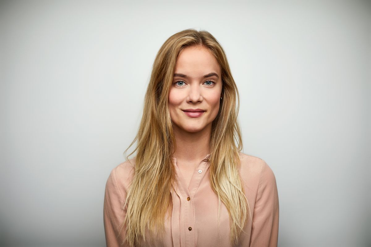 Egy szőke nő mosolygás közben gödröcskékkel az arcán.