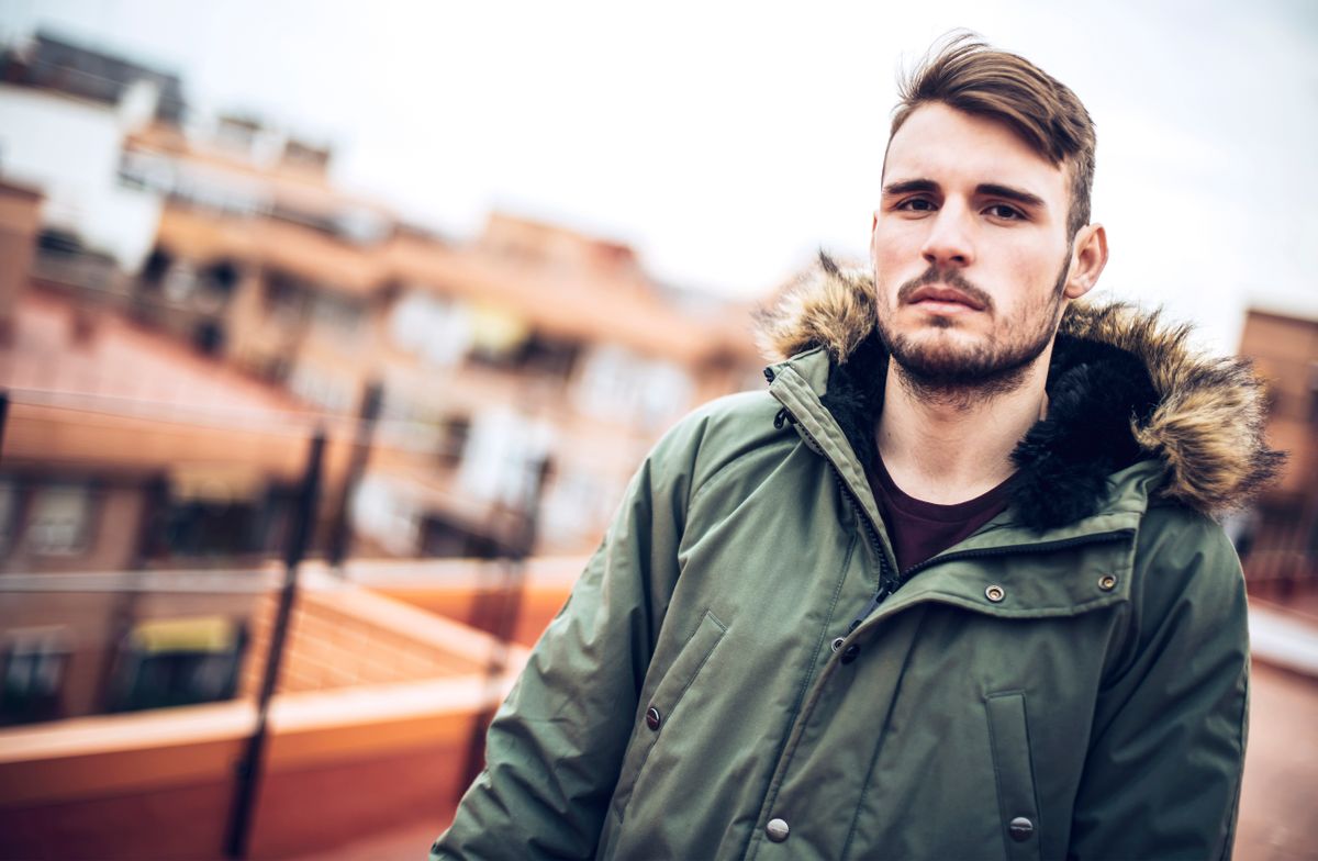 Férfikabátok: Egy szakállas férfi parka kabátban mosolyog a kamerába.