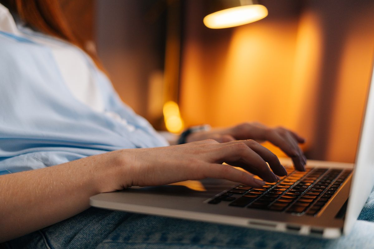 Erotikus csalással küzdő nő a laptop előtt ülve.