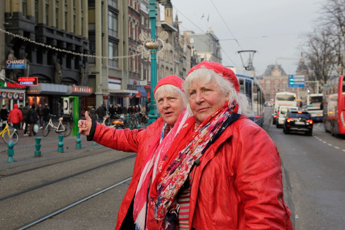 TO GO WITH AFP STORY BY JAN HENNOP
Twins Martine (L) and Louise Fokkens (R), 70, walk around the centre of Amsterdam on November 15, 2012, the Netherlands. Twins Martine and Louise Fokkens, nicknamed the 'Queens of the wallen', are Amsterdam's oldest prostitutes, having worked for fifty years in the city's red-light-district, and they have wrote two books about their experiences.  AFP PHOTO / Anoek de Groot (Photo by ANOEK DE GROOT / AFP)