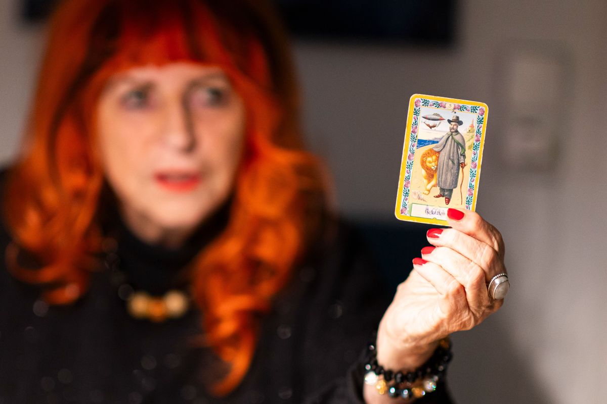 Tartot jóslatot végző nő kártyát tart a kezében.