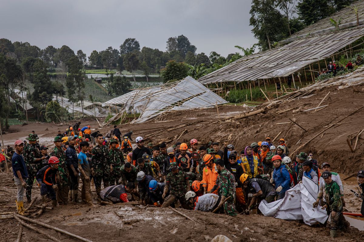 BANDUNG, WEST JAVA, INDONESIA - JANUARY 25: Indonesian search and rescue teams carry the body of a landslide victim in Pasirlangu village on January 25, 2026 in Bandung, West Java, Indonesia. 25 people were killed and at least 80 still missing following the deadly landslide, local media reports said. (Photo by Ulet Ifansasti/Getty Images)