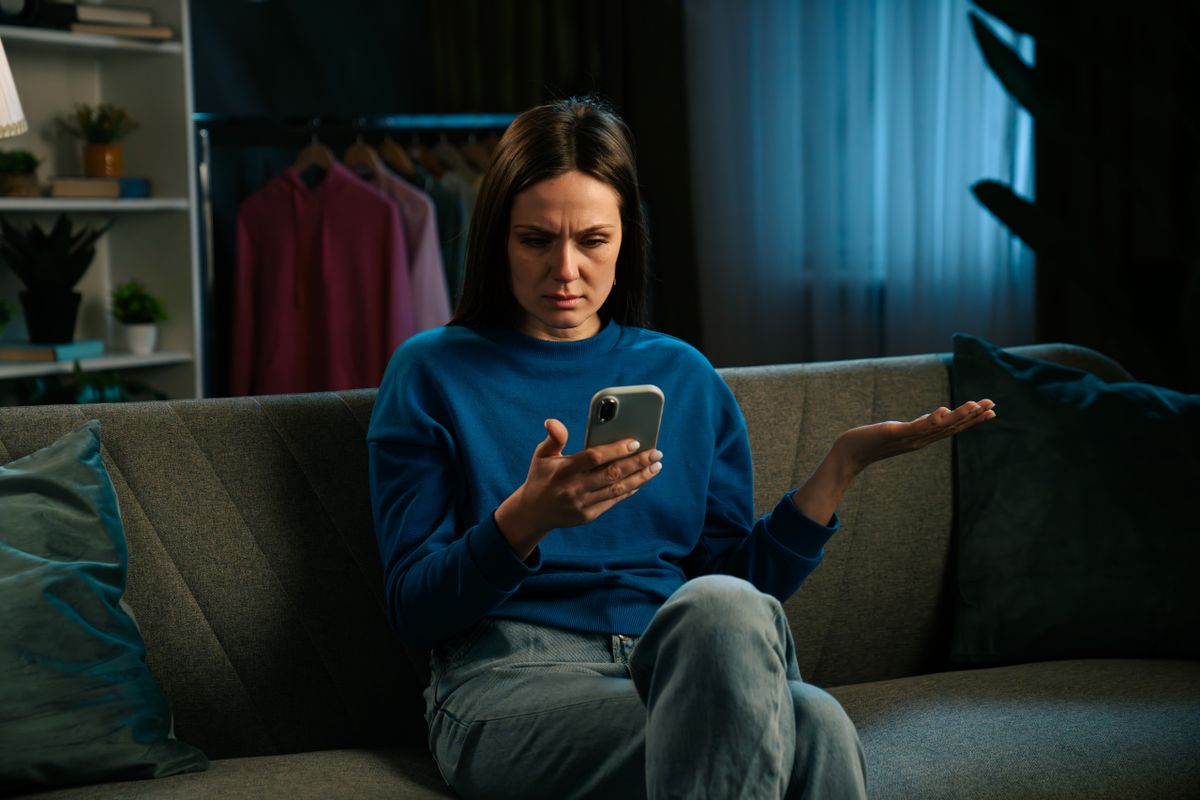 Fiatal nő egy IQ-tesztet próbál megoldani a telefonján 