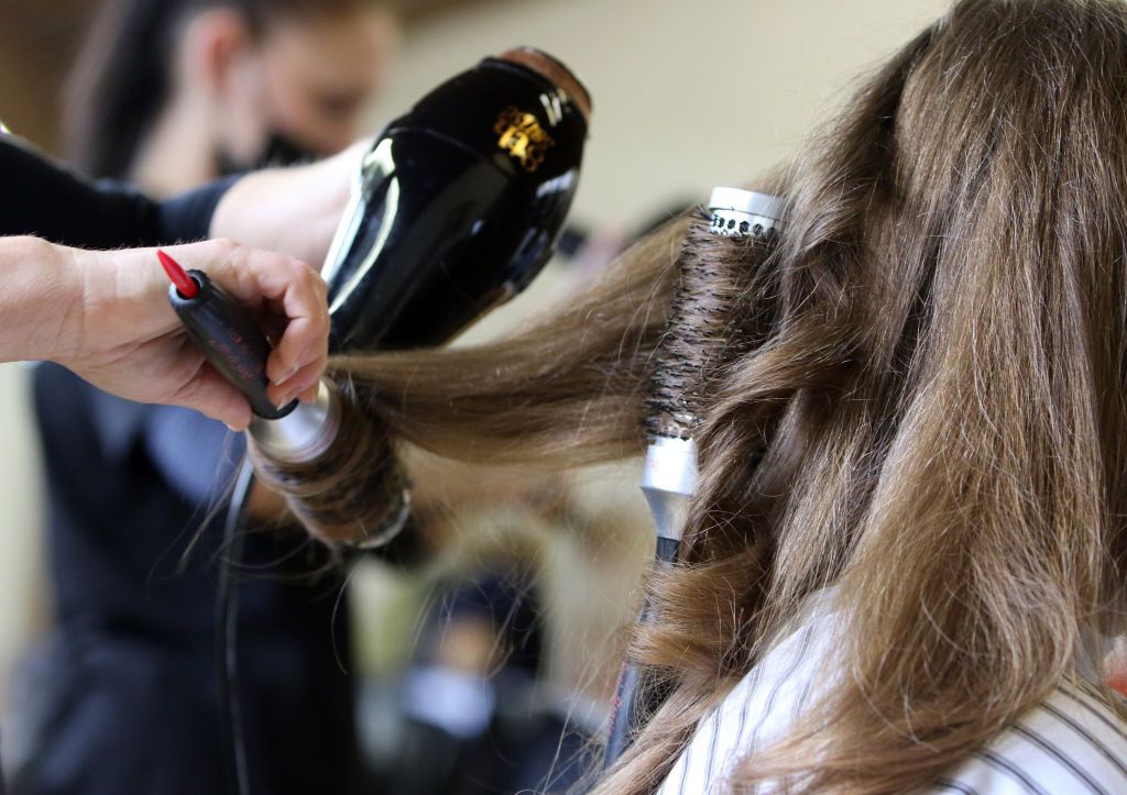 Fodrász hajat szárít.