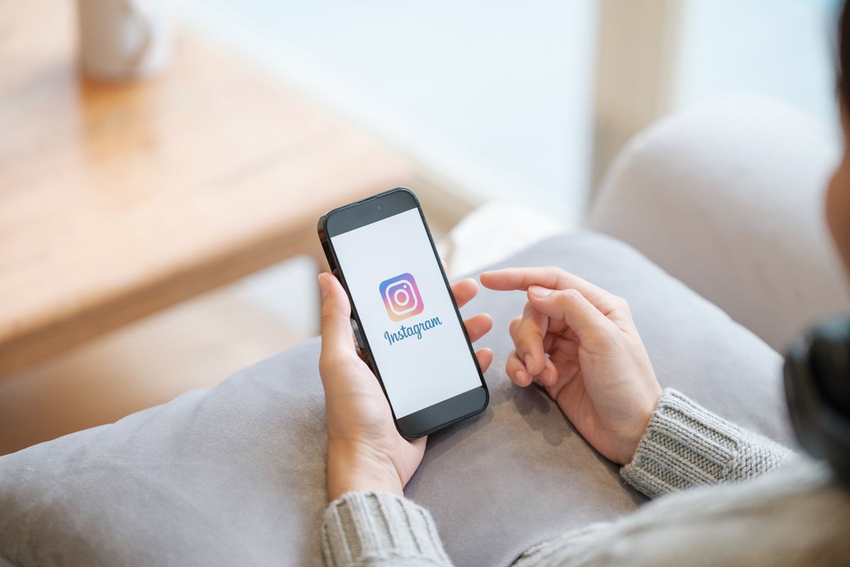 Instagram-baki, a nő a telefonján nézegeti az oldalt.