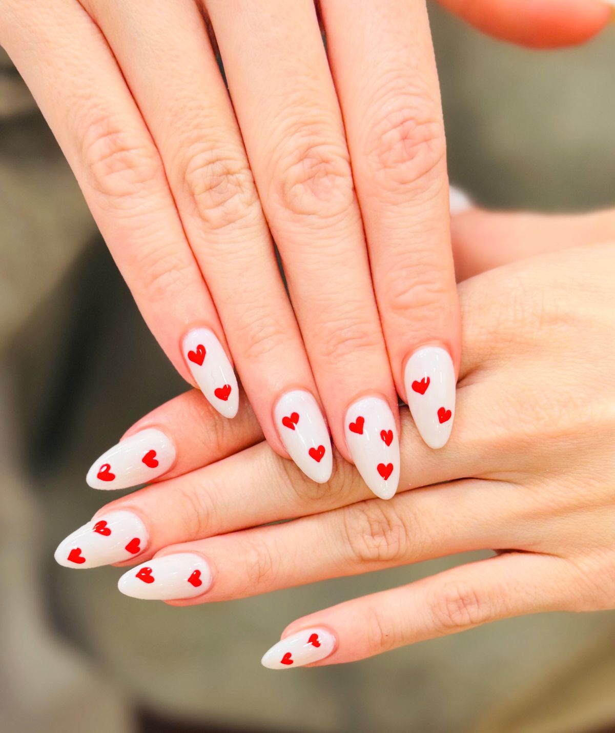 Woman with heart white nails design. Manicure. Nail salon. Classic bridal nail design. Fashion makeup and cosmetics. Valentine's day