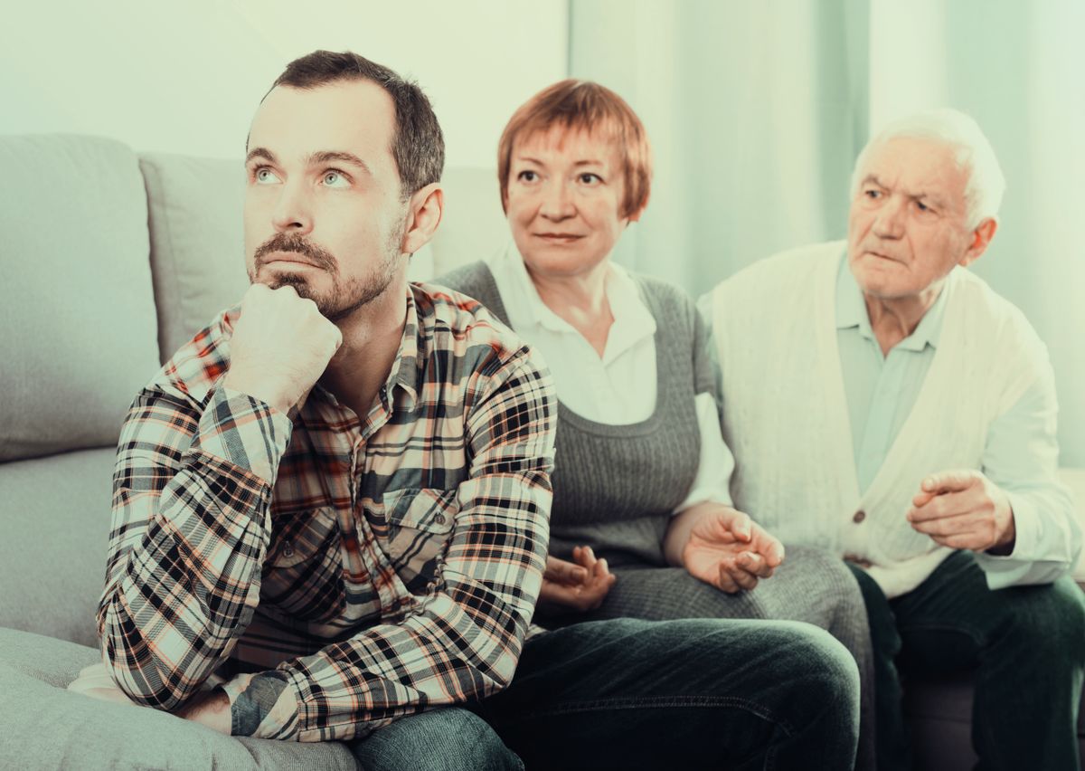 Adult Children jelenség: harmincas fiatal felnőtt beszélget a szüleivel az otthonukban.