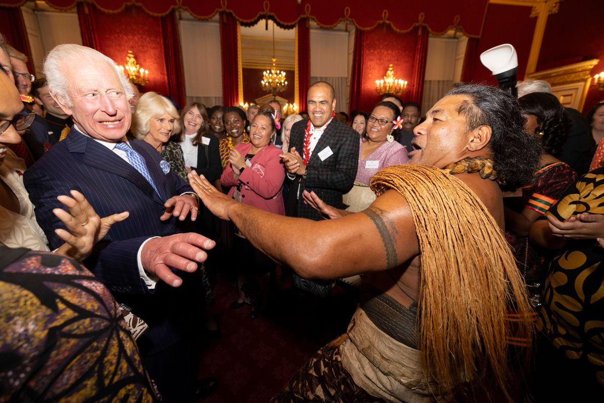 LONDON, ENGLAND - OCTOBER 02: Britain's King Charles III reacts alongside Queen Camilla as former Samoan rugby player Freddie Tuilagi dances during a reception to celebrate the Commonwealth Diaspora of the United Kingdom, ahead of the Commonwealth Heads of Government Meeting in Samoa, at St. James's Palace on October 2, 2024 in London, England. The reception, for around 300 guests, will recognise and celebrate the huge contribution made by the Commonwealth. (Photo by Jeff Gilbert - WPA Pool/Getty Images)