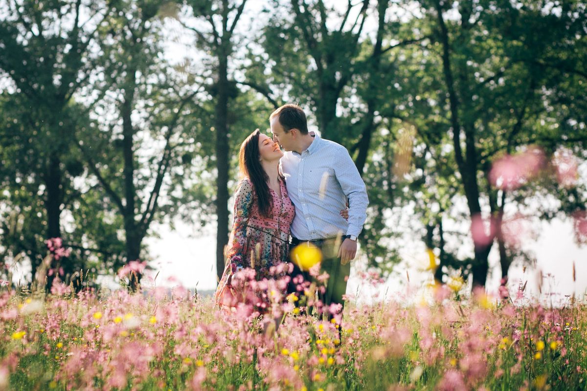 csillagjegyek, illusztrációként egy szerelmes pár andalog egy virágos mezőn