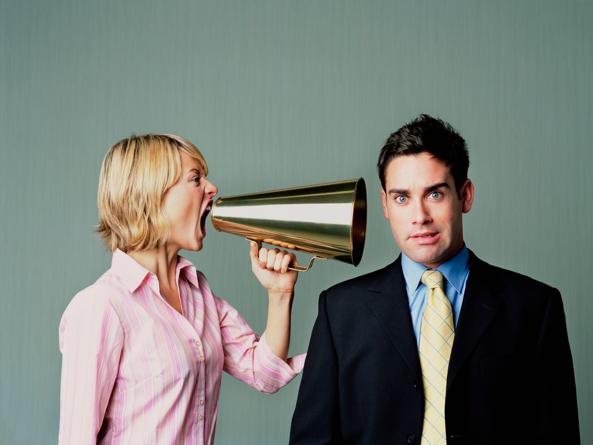 Egy nő egy papucsférjet lekiabál egy megafonnal. 