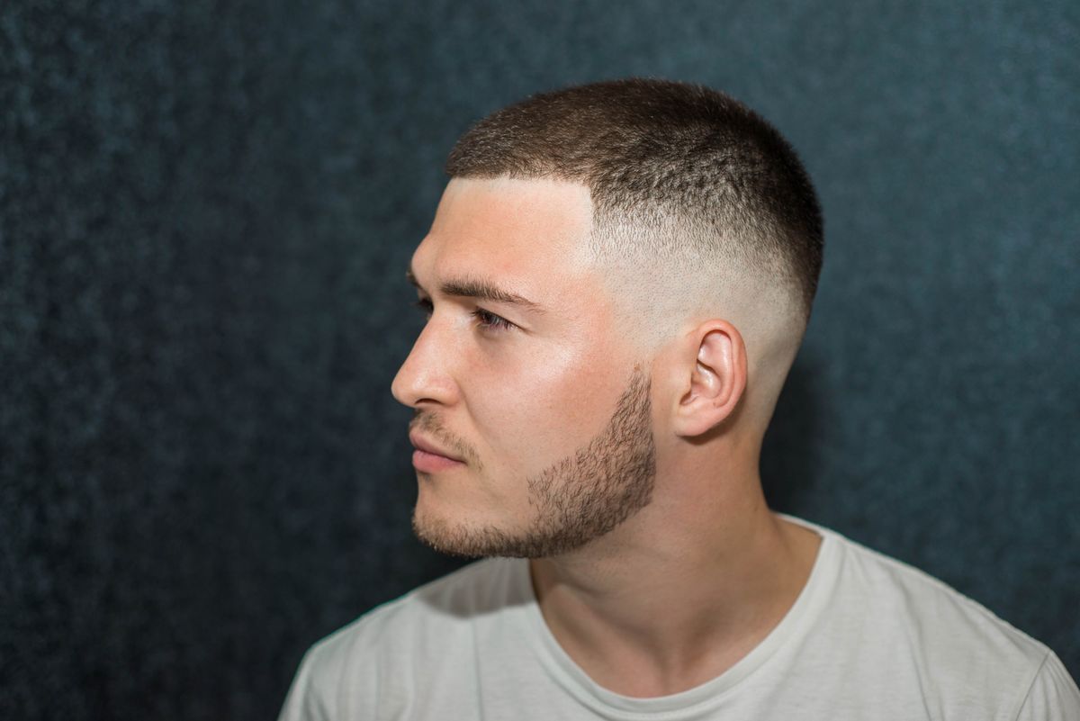 sport young man with a modern trendy fade profile haircut for barbershop.