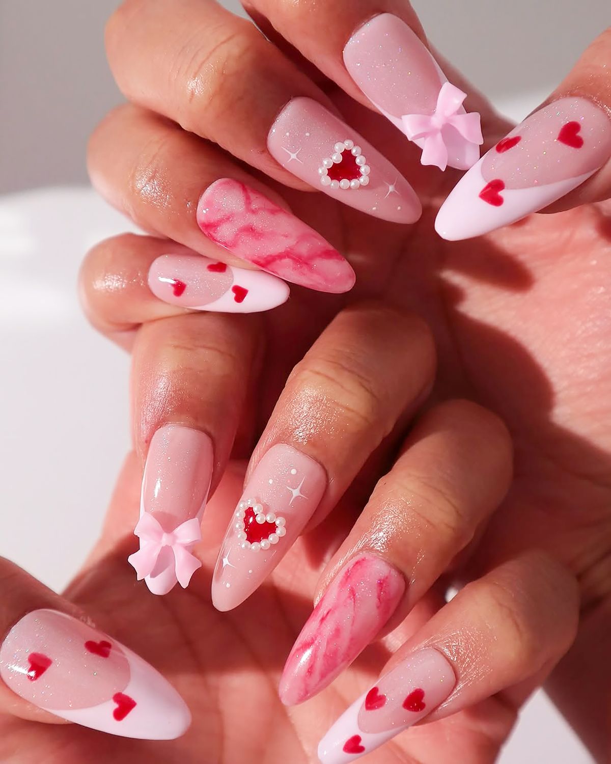 Női kéz Valentin napi körmökkel.