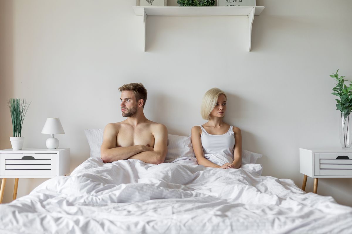Egy nő és egy férfi csenddel büntetés közben az ágyban, nem kommunikálnak egymással. 
