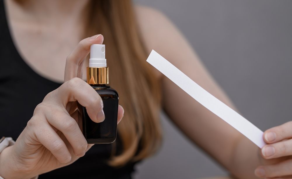 Nő és pézsma illat parfümös üvegből fújva. 