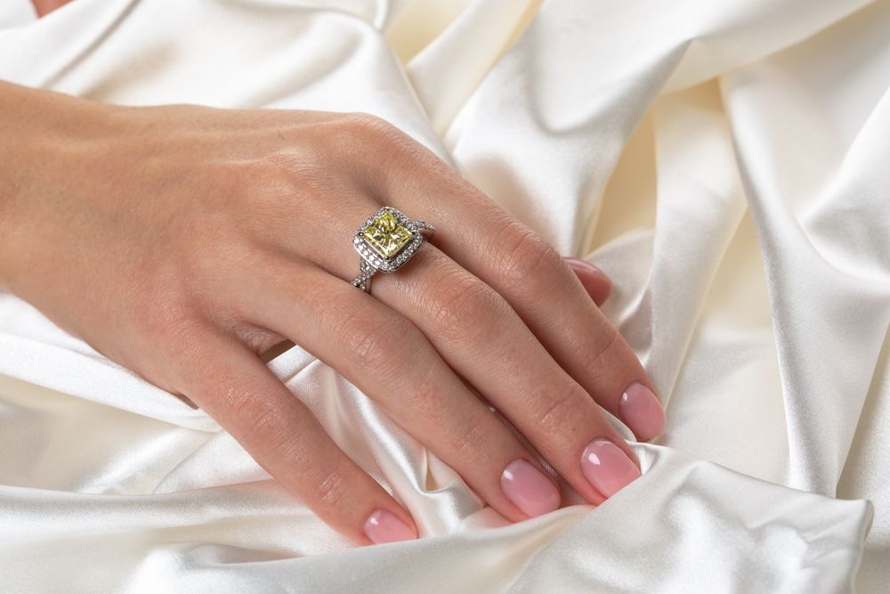 sárgás, mézes tónusú eljegyzési gyűrű nő kezén