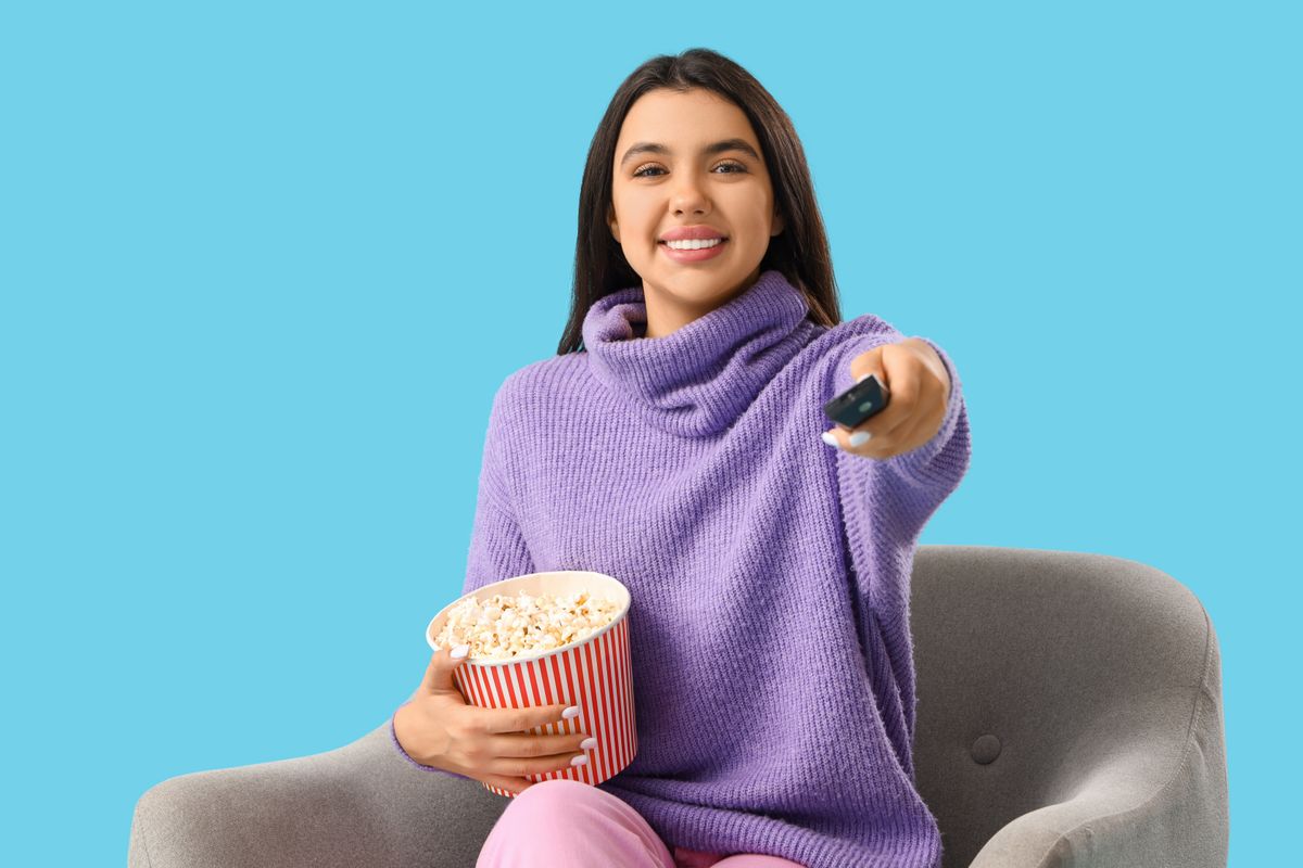 Kultfilmes kvíz: lány távirányítóval és popcornnal a kezében.