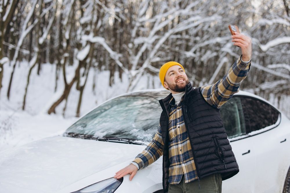Férfi szelfizik, háttérben autó, profilkép készül. 