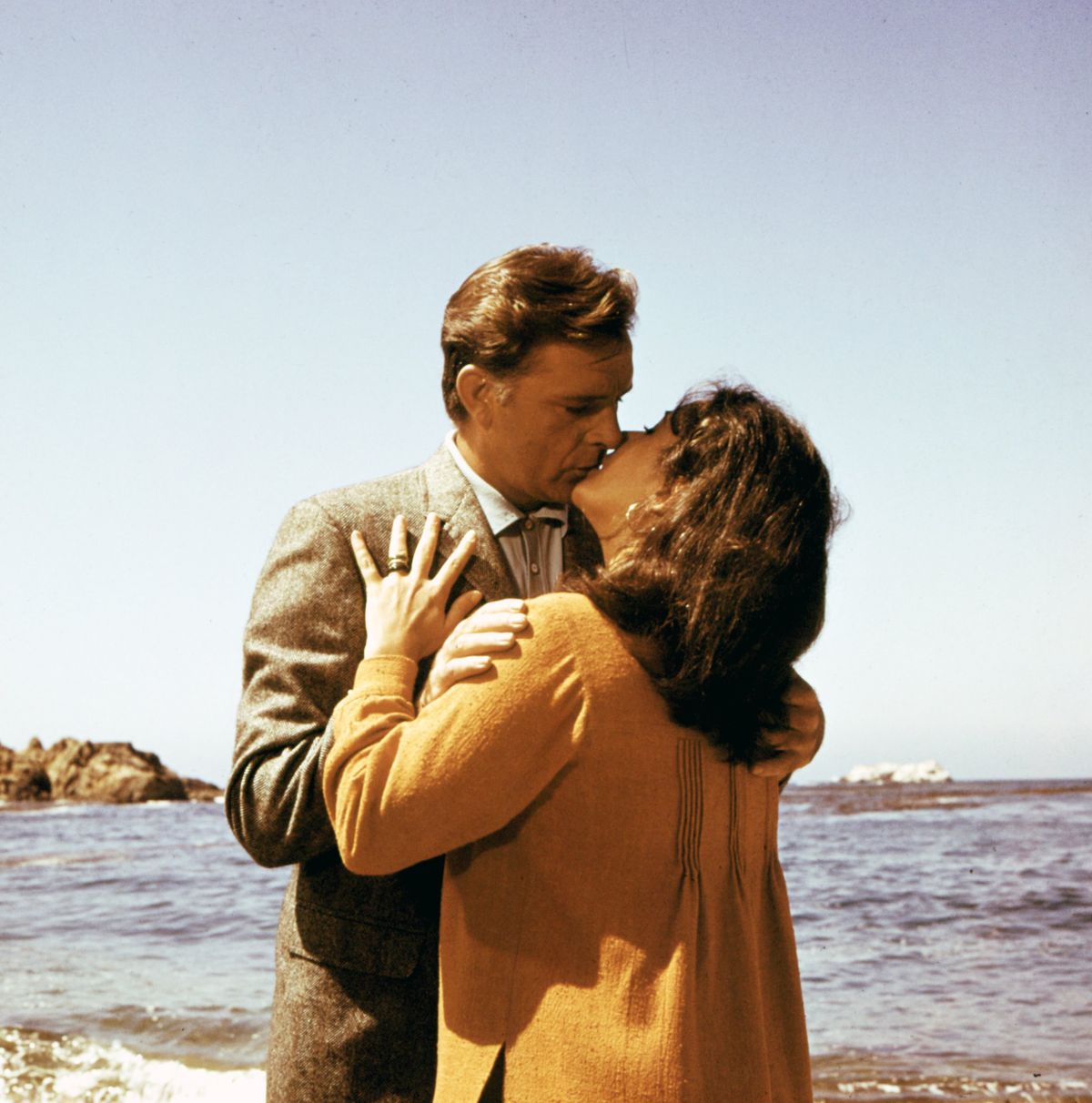 JUNE 23:  Husband and wife actors Elizabeth Taylor and Richard Burton kiss in a scene from the movie 'The Sandpiper' which was released on June 23, 1965. (Photo by Michael Ochs Archives/Getty Images)