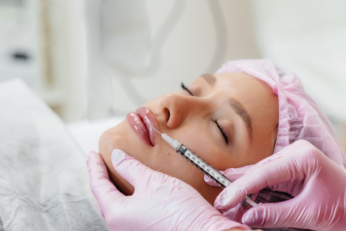 Cosmetology procedure for lip augmentation and wrinkle removal for a young beautiful girl. Cosmetology