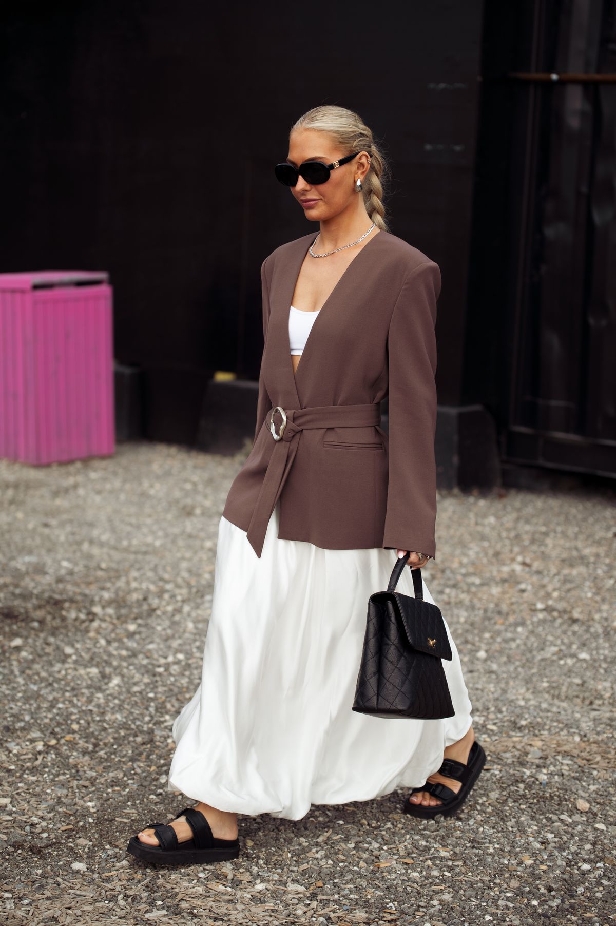 Fiatal nő blézerben szoknyában és chunky szandálban 