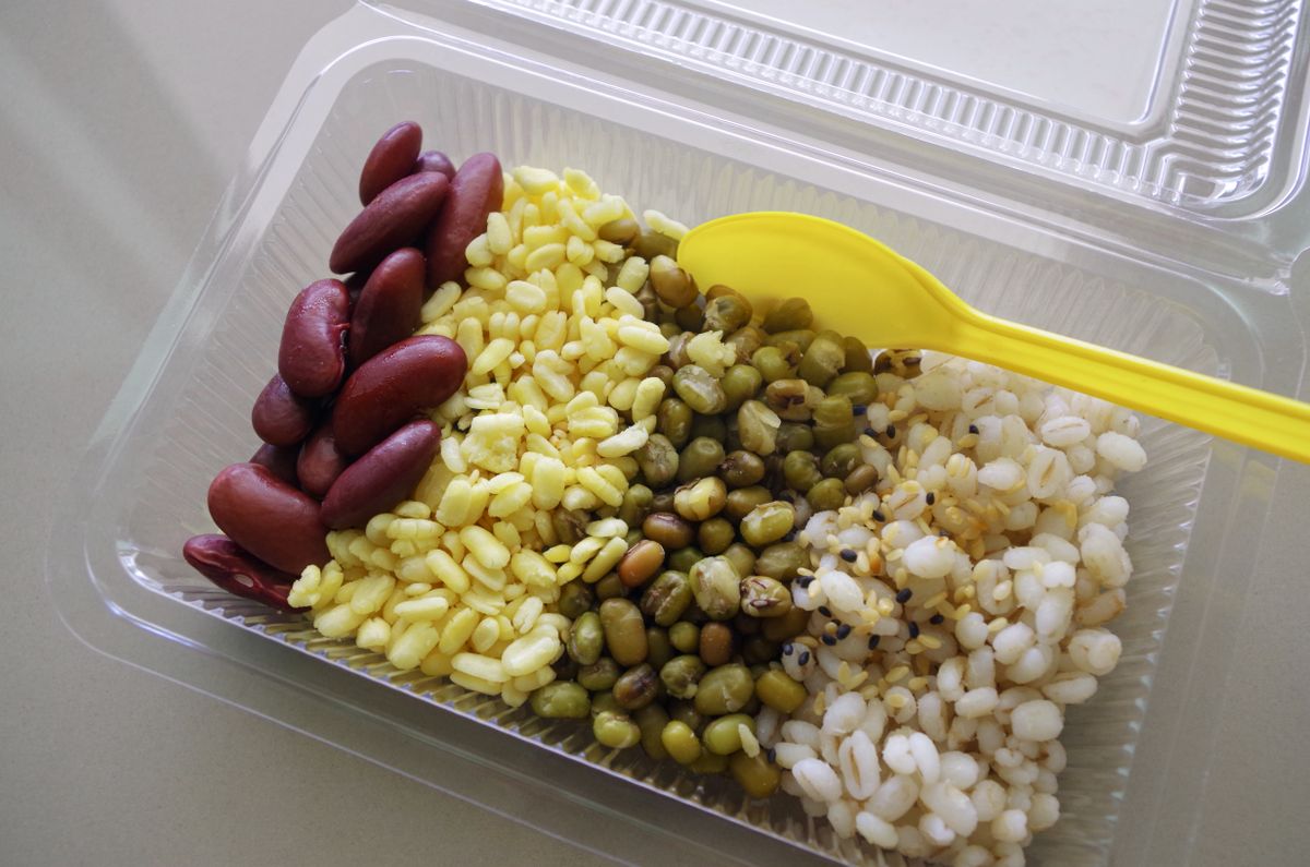 A detailed close-up image showcasing a variety of healthy grains and beans, including barley, mung beans, yellow split peas, and red kidney beans. The texture and natural colors of these nutritious ingredients are captured beautifully, emphasizing their organic and wholesome qualities.
